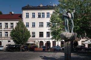 Una estatua de dos personas en una roca frente a un edificio. en Amazing apartament in the heart of Kazimierz, en Cracovia