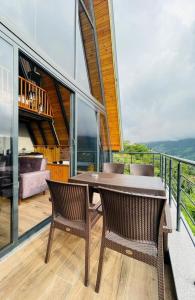 a dining room with a table and chairs on a balcony at Seyr-i Keyf Suit Bungalov in Rize