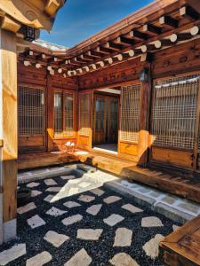 an entrance to a wooden building with a stone courtyard at Unwadang Private Luxury Hanok House in bukchon in Seoul