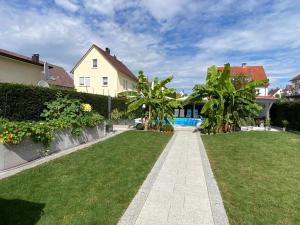 a lawn with palm trees and a house at #5 HQ Studio in bester Lage in Friedrichshafen