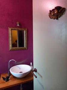 a bathroom with a sink and a mirror on a wall at Casa rural Olivar de Albarizas in Fernancaballero