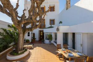 een patio met een tafel en een boom bij Casa Colomer in Canet de Mar