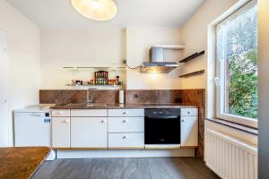a kitchen with white cabinets and a sink and a window at Haus Sonnenschein in Pahlen