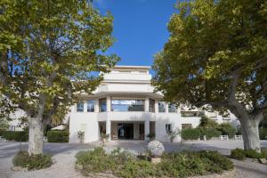 a white building with trees in front of it at Grand studio à 5 minutes à pied de la plage in La Ciotat