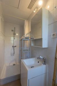 a white bathroom with a sink and a shower at Grand studio à 5 minutes à pied de la plage in La Ciotat