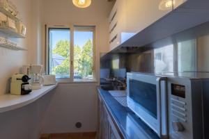 a kitchen with a microwave on a counter at Grand studio à 5 minutes à pied de la plage in La Ciotat +14 photos