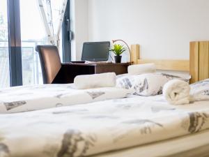 three beds in a room with a desk and a computer at Hostel Moving in Zagreb