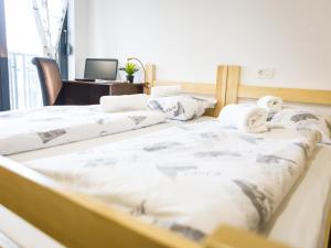 Dos camas en una habitación con una computadora en un escritorio. en Hostel Moving, en Zagreb