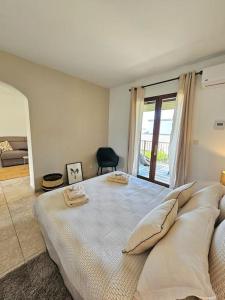 una camera bianca con un grande letto con cuscini di Bel appartement avec piscine Cap Corse- Sisco a Marine de Sisco Altre 50 foto