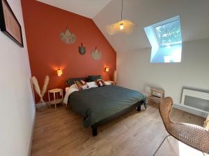 a bedroom with a bed in a room with orange walls at Belle maison au calme avec parking in Bretteville-sur-Odon