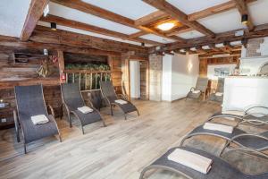Großes Zimmer mit Stühlen und Holzwänden in der Unterkunft Berggasthof Hochzeigerhaus in Jerzens