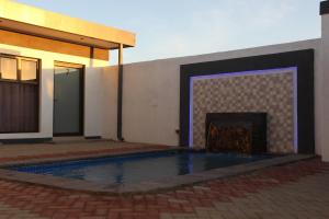 a swimming pool in front of a building with a fireplace at Golden View Boutique Guesthouse in Windhoek