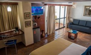 a living room with a bed and a couch and a table at Hotel Puerto Playa Suites in El Morro de Barcelona