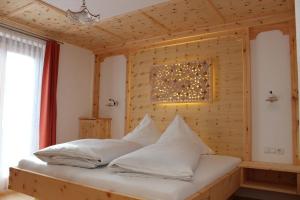 uma cama num quarto com uma parede de madeira em Pension Widmann em Stulles