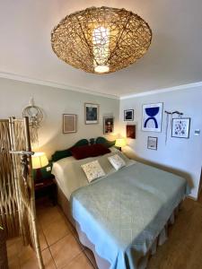 ein Schlafzimmer mit einem Bett und einem Kronleuchter in der Unterkunft Studio Céladon village vacances Ste Anne Guadeloupe in Sainte-Anne + 30 Fotos