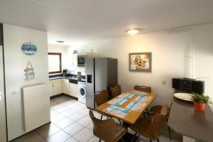 Una cocina y un comedor con una mesa y un refrigerador. en Wijk de Brabander 117, en Cadzand