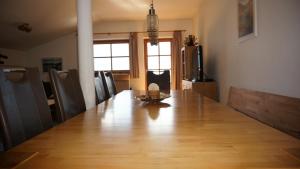 a long dining room table with chairs and a television at Panorama-Apartment Fürth in Aufhausen +20 photos