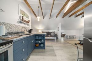 a kitchen with blue cabinets and a living room at The 1885 Suites in Picton