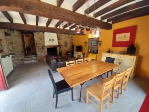 a living room with a wooden table and chairs at Les longères du Trieux in Lézardrieux