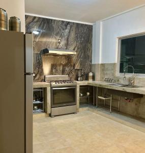 a kitchen with a stainless steel stove and a sink at Departamento Purisima Ubicacion Estrategica y Amplio Zona Alameda Cerca del Centro in San Francisco del Rincón