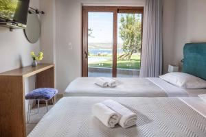 Dos camas en una habitación con vista al mar. en Villa Koule, en Kalami 20 fotos más