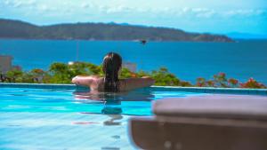 邦比尼亚斯Pousada do Arvoredo的游泳池里的一个女人,看着水