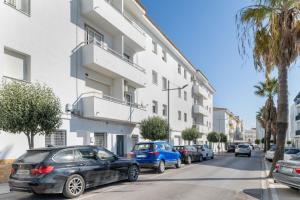 a row of cars parked in front of a building at Apartamento Calderon in Barbate