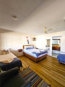 une grande chambre avec deux lits et un canapé dans l'établissement Kilcoy Motel, à Kilcoy 74 autres photos