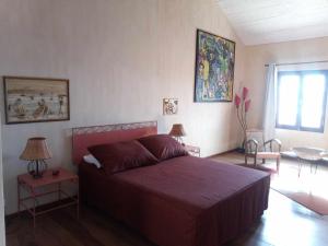 a bedroom with a bed with a red bedspread at Casa Azul in Mindelo