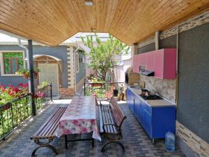 an outdoor kitchen with a table and a bench on a patio at Garden Gabala-Villa1 in Gabala
