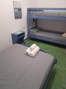 1 dormitorio con 2 literas y toallas en Hotel Pourally, en Villa Gesell