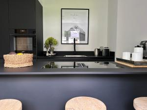 a kitchen with a black counter with a sink at Romantikhütte Winterberg-Willingen in Medebach