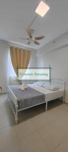 a bed in a white room with a ceiling at D'roomah Homestay in Sepang +4 photos
