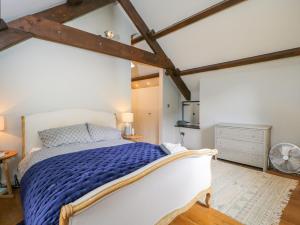 a bedroom with a large bed with a blue blanket at The Ivy Barn in Abergavenny