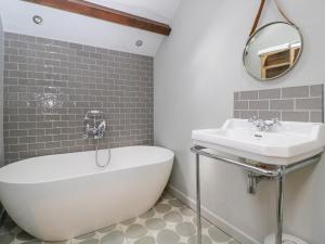 a bathroom with a white tub and a sink at The Ivy Barn in Abergavenny +39 photos