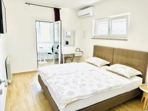 a bedroom with a bed and a desk and window at Apartmani MARCO,LUKAS,PATRICK,DAVID,blizu centra i mora sa FREE privatnim parkingom in Pula