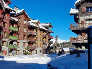 アーク 1950にあるArc 1950, Sources de Marie, 6-8 personnes, 70 m2, calme et spacieux, au pied des pistes, classement 5 Cristaux Paradiskiの雪中の一列のアパートビル