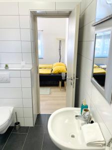 a bathroom with a sink and a bed in a room at Lator Apartmanház in Villány