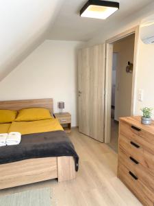 ヴィッラーニにあるLator Apartmanházのベッドルーム1室(大型ベッド1台、木製ドレッサー付) +25枚の写真