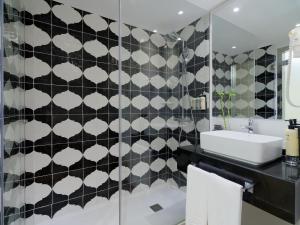 a bathroom with a black and white tiled wall at H10 Gran Tinerfe - Adults Only in Adeje