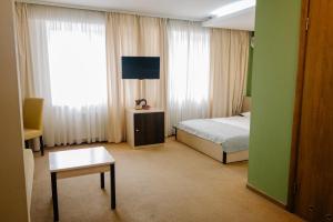 Televízia a/alebo spoločenská miestnosť v ubytovaní 7 Days Hotel Kamyanets-Podilskyi