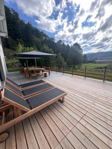 a deck with a picnic table and an umbrella at LE GITE DES ABEILLES in Rupt-sur-Moselle