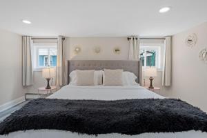 a bedroom with a large bed with two windows at Beautifully Renovated 6BR 2BA 2 Blocks to Beach in Atlantic City