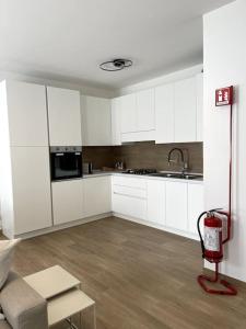 Una cocina con gabinetes blancos y un extintor rojo. en 2612 HOUSE piano terra garage e wi-fi, en Verona