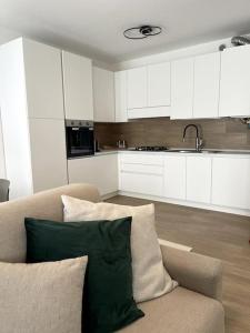 Una sala de estar con un sofá y una cocina. en 2612 HOUSE piano terra garage e wi-fi, en Verona