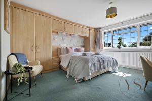 a bedroom with a bed and a chair and a window at Spacious 6BR Villa in 32 Le More Birmingham with 7 Beds and Free Onsite Parking in Birmingham