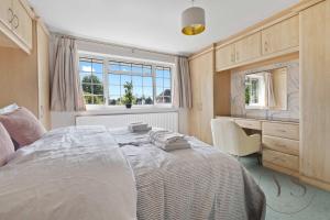 a bedroom with a bed and a desk and a window at Spacious 6BR Villa in 32 Le More Birmingham with 7 Beds and Free Onsite Parking in Birmingham +62 photos