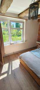 a bedroom with a bed and two windows at Apartament nad morzem z podwórkiem in Będzino