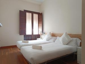 A bed or beds in a room at Apartamentos Palacio de los Jerónimos