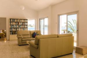 Una sala de estar con un sofá y una estantería. en Coral Bay Beach House Apartment, en Peyia